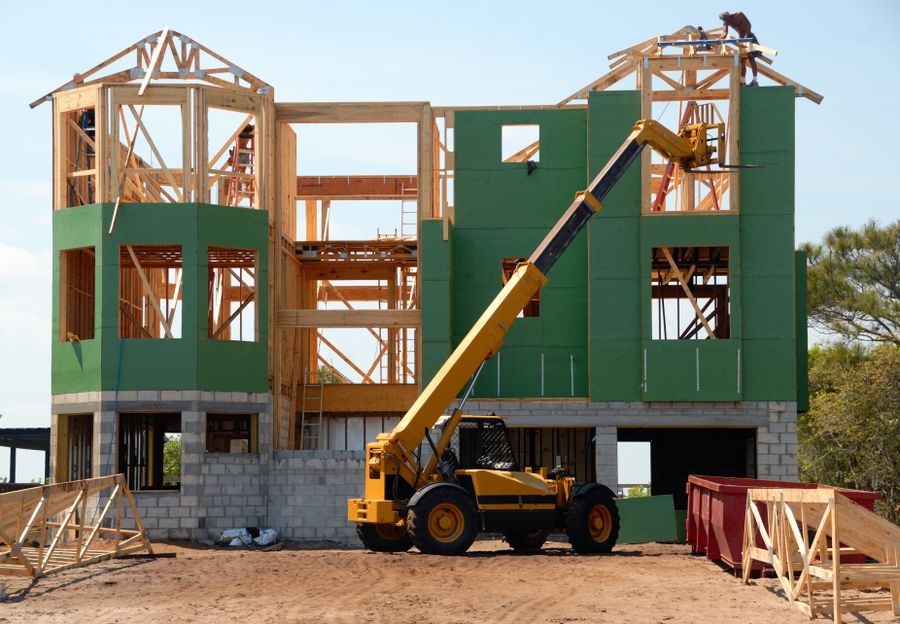 Timber-frame building under construction with a crane